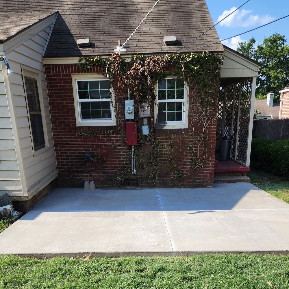 A brick house with a concrete driveway in front of it