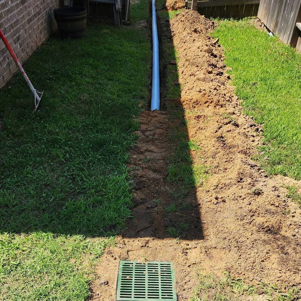 A drainage system is being installed in the backyard of a house.