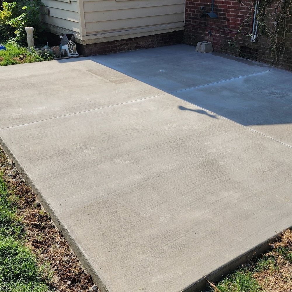 A concrete walkway is sitting in front of a brick house.