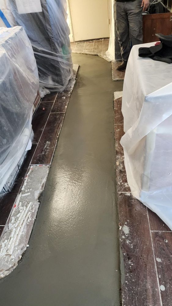 A man is standing in a room with a concrete floor.