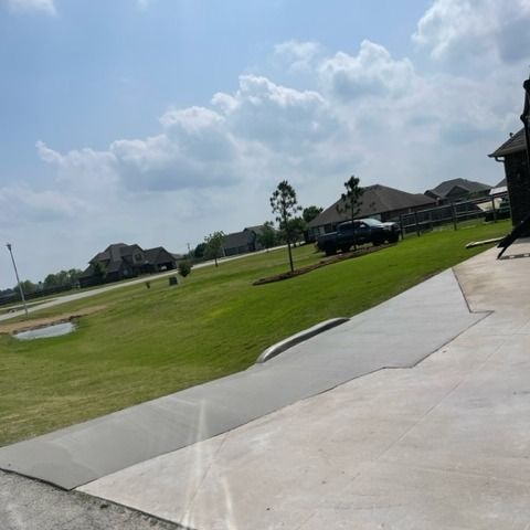A black truck is parked in the grass in front of a house.