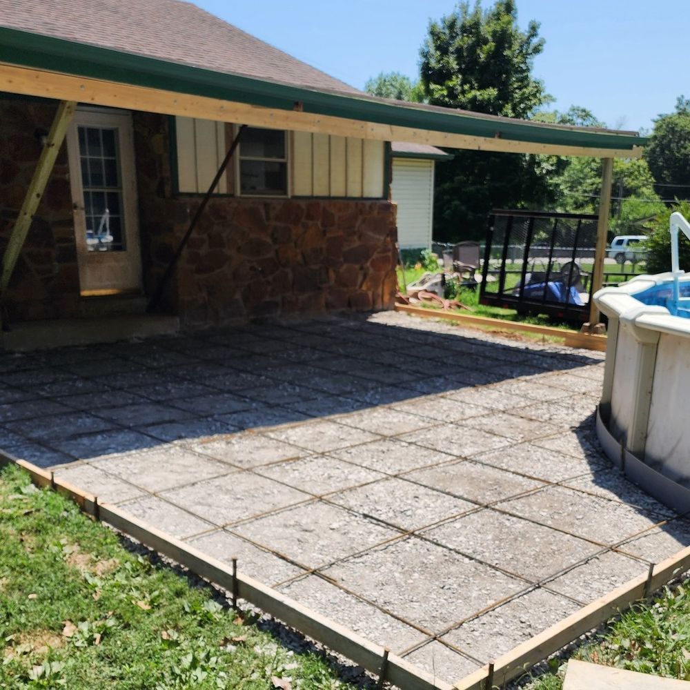 A concrete patio is being built in front of a house