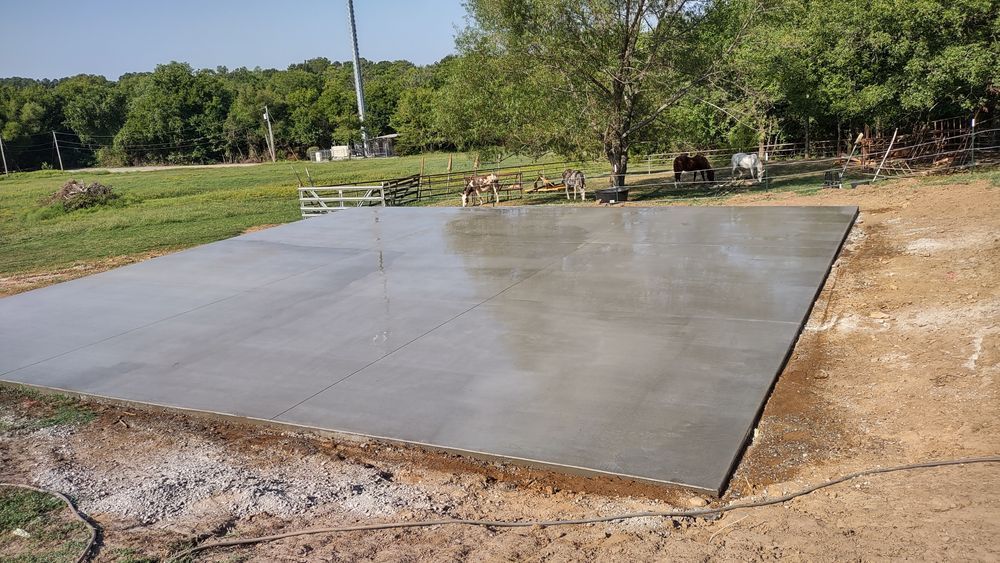 A large concrete slab is sitting in the middle of a dirt field.