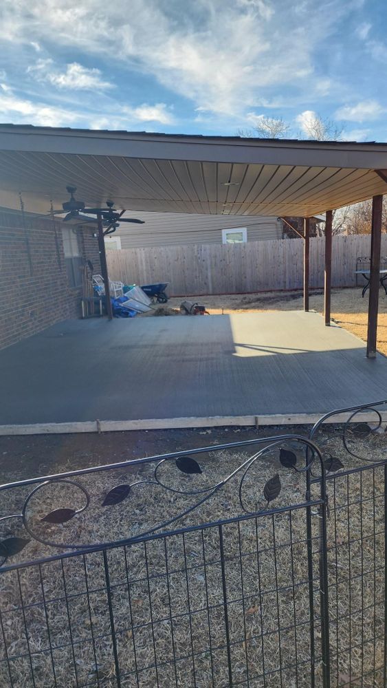There is a carport with a ceiling fan in the backyard.