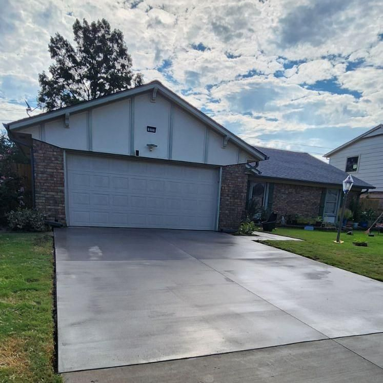 A brick house with a white garage door and a concrete driveway