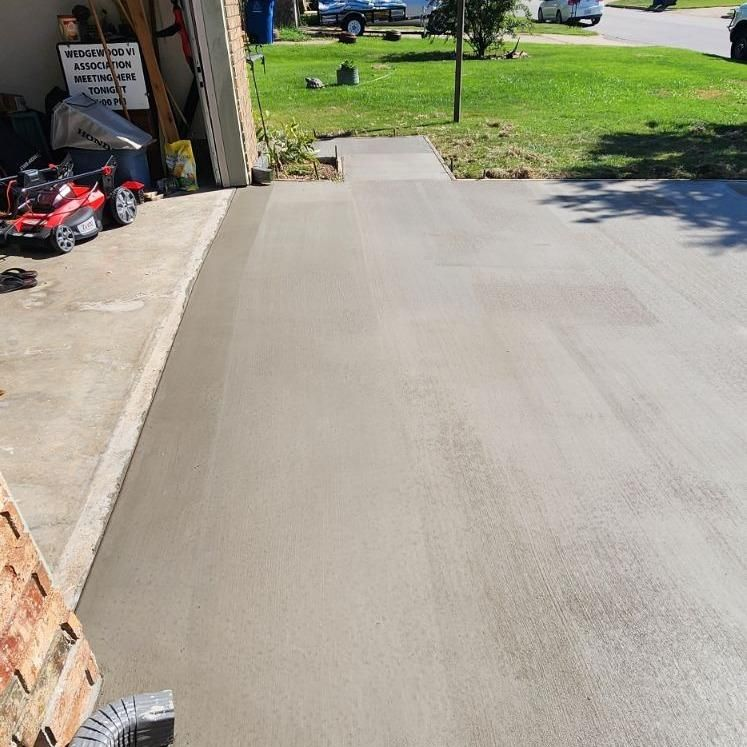 A concrete driveway is being built next to a garage.
