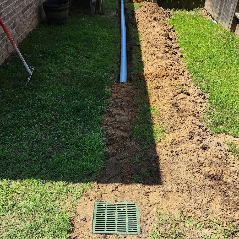 A drainage system is being installed in a backyard.