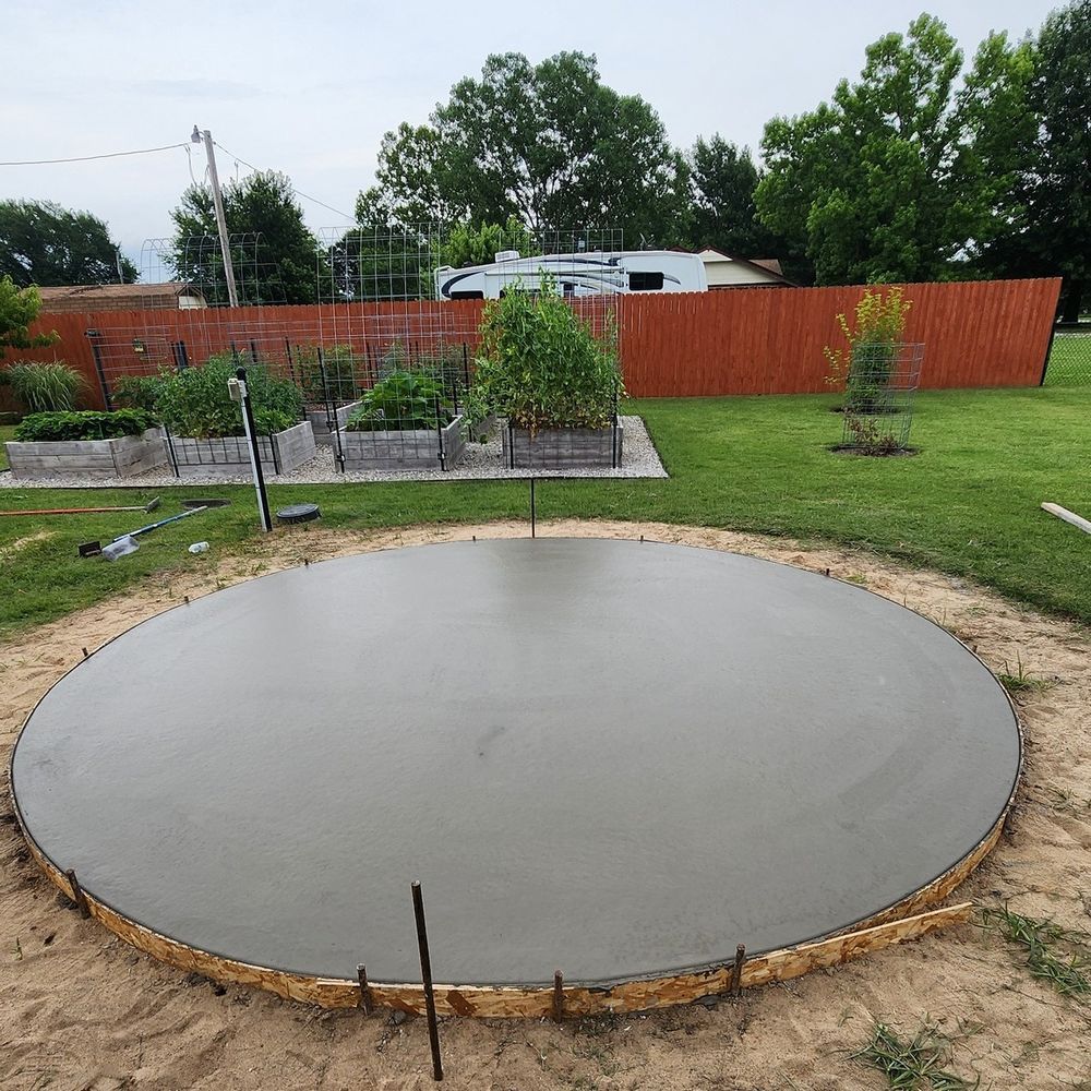 A large concrete circle is being built in a backyard.