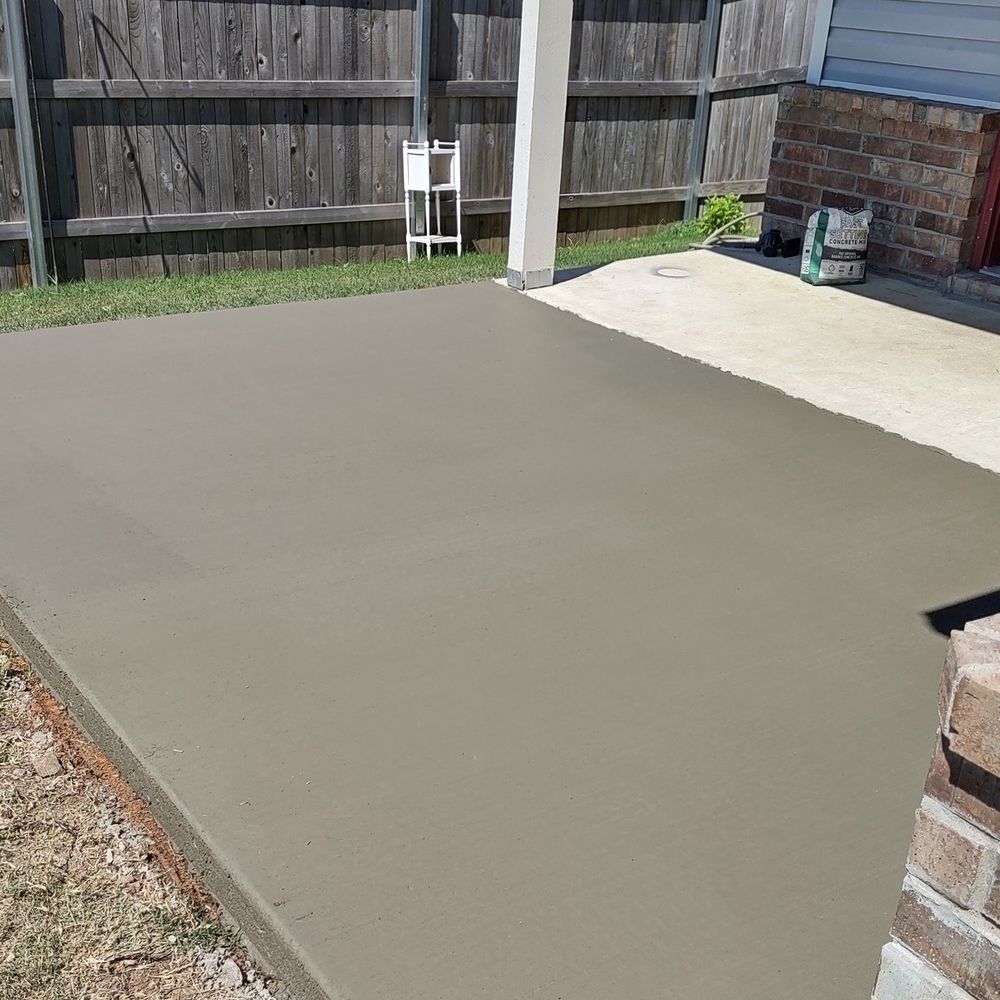 A concrete patio with a wooden fence in the background.
