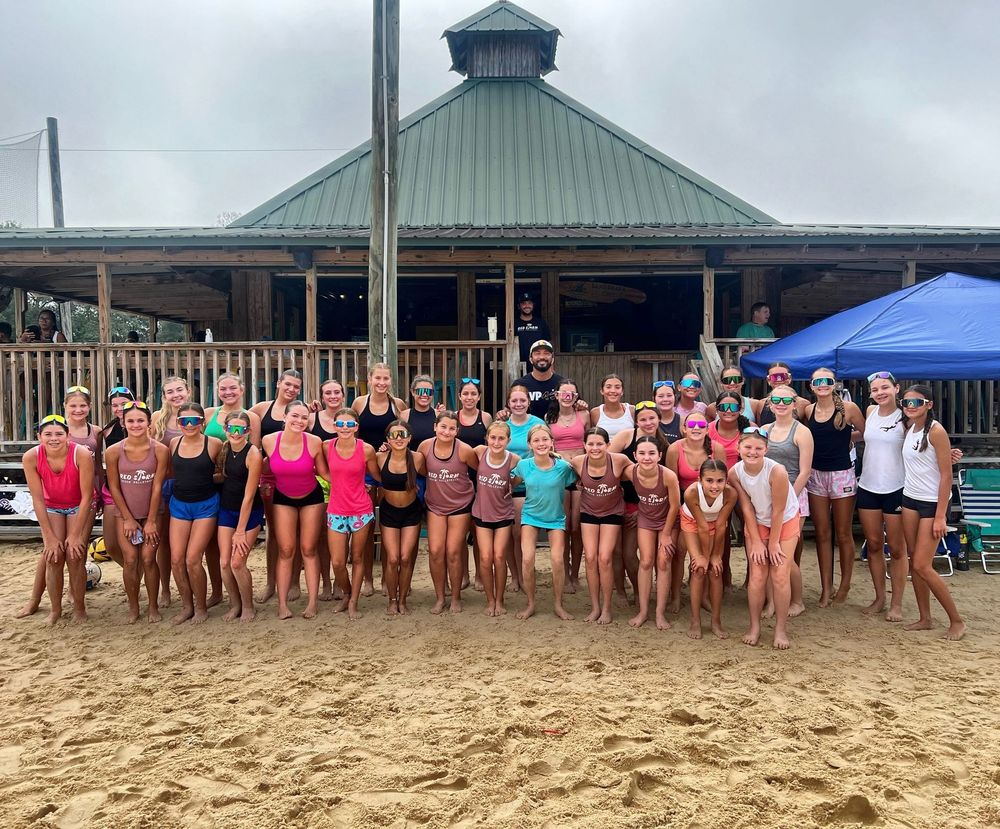 Baseball glove with ball on green grass, with blurred baseballs in the background.