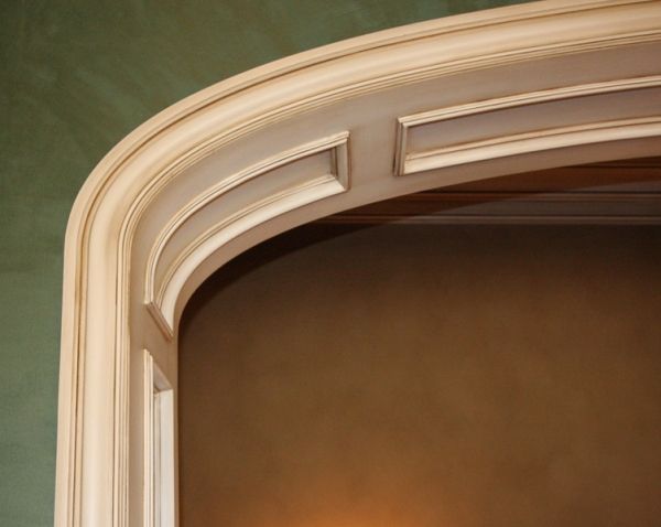 A close up of a wooden archway with a green background
