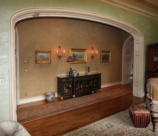 A living room with a dresser and paintings on the wall