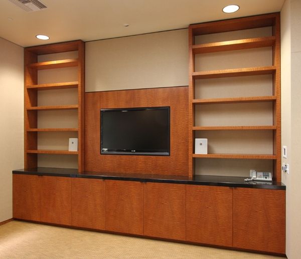 A living room with a flat screen tv and shelves