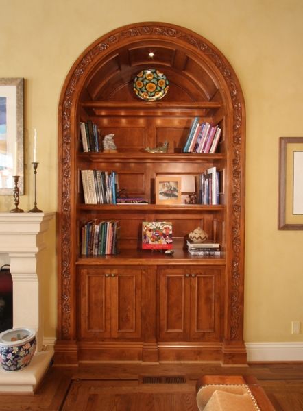 A living room with a bookshelf and a fireplace