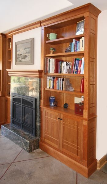 A living room with a fireplace and a bookshelf