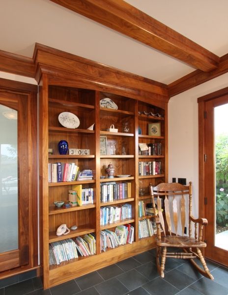 A rocking chair sits in front of a bookcase filled with books