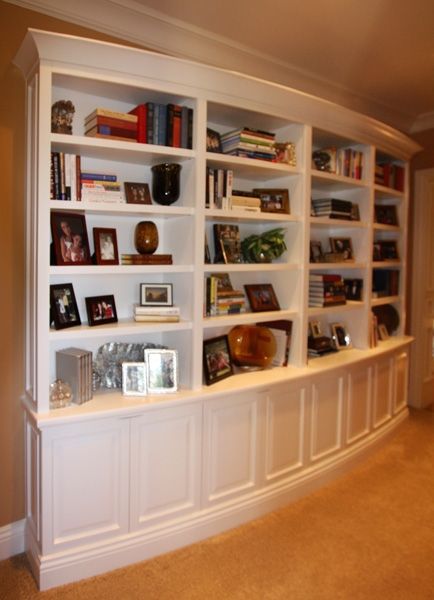 A bookcase with a lot of books and pictures on it