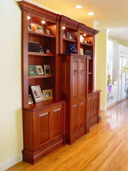 A large wooden cabinet with pictures on the shelves