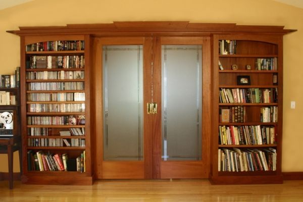 A library with lots of books and sliding glass doors