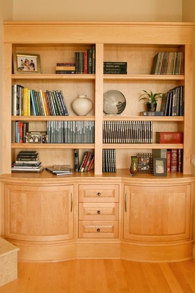 A wooden bookcase filled with books and pictures
