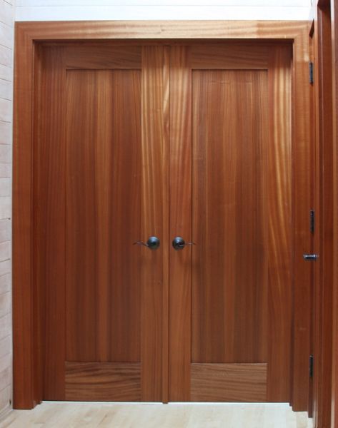 A pair of wooden doors with black knobs