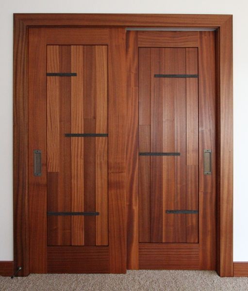 A pair of wooden doors with black straps on them