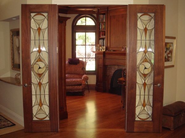 A living room with stained glass doors and a fireplace