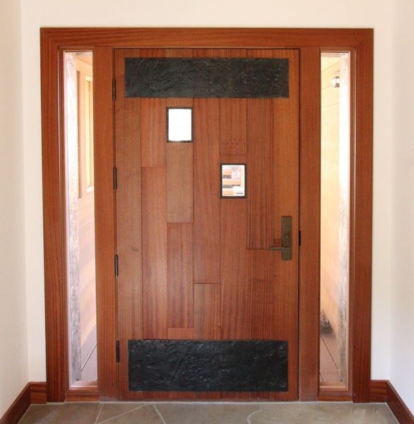 A wooden door in a hallway with two windows