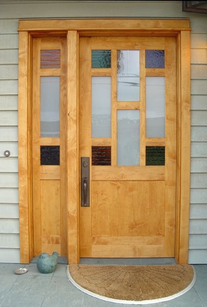 A wooden door with stained glass and a door mat