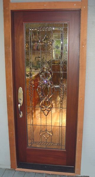 A wooden door with a stained glass window in a kitchen.