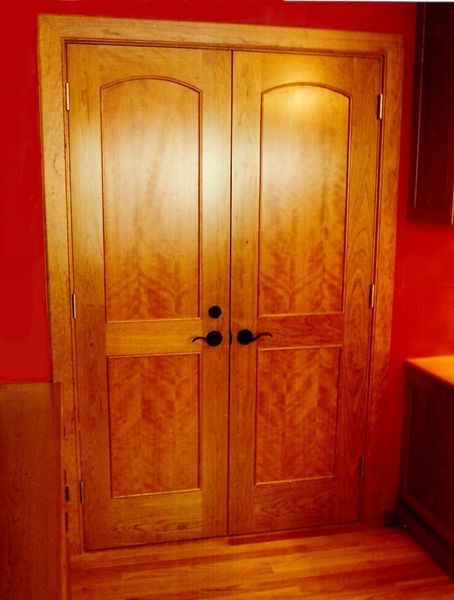 A pair of wooden doors in a room with red walls