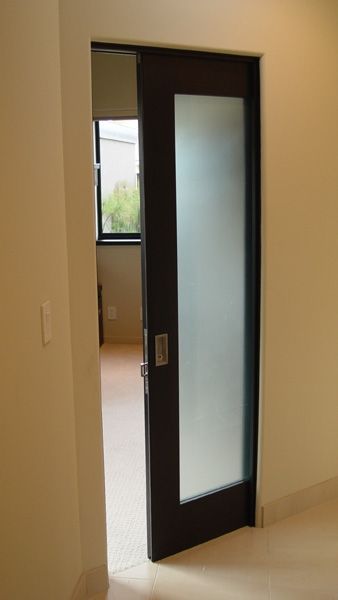 A sliding glass door in a room with a window.