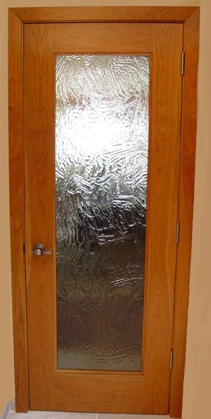 A wooden door with a glass window in it.