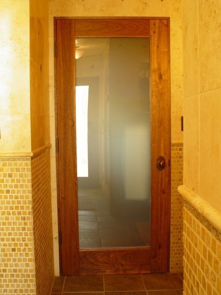 A hallway with a wooden door and a glass door