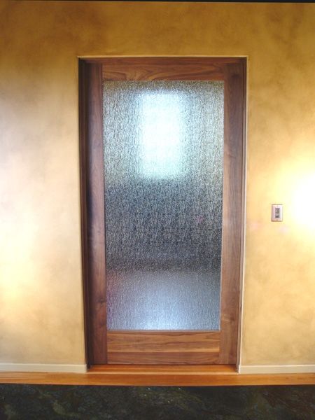 A wooden door with a glass window in a room.
