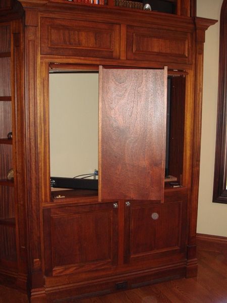 A wooden entertainment center with a sliding door