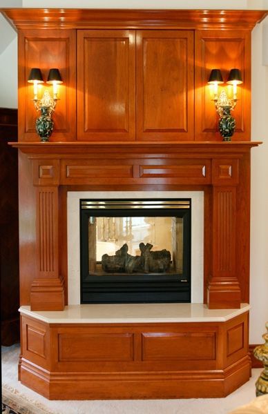 A fireplace in a living room with a wooden mantle