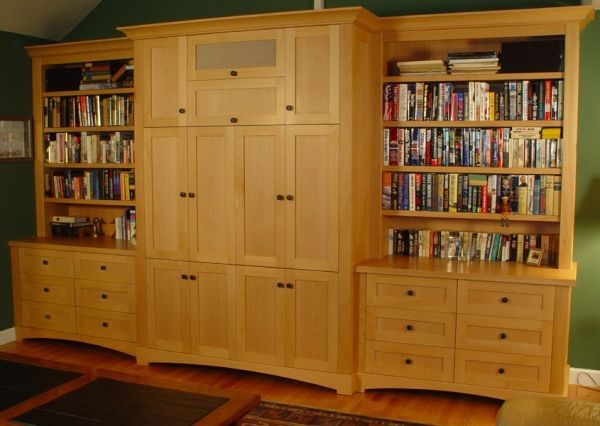A living room with lots of books on shelves and cabinets