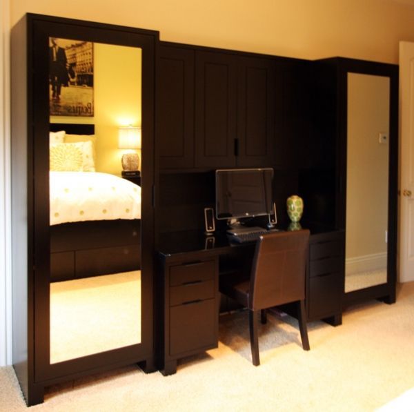 A bedroom with a desk and chair and a large mirror
