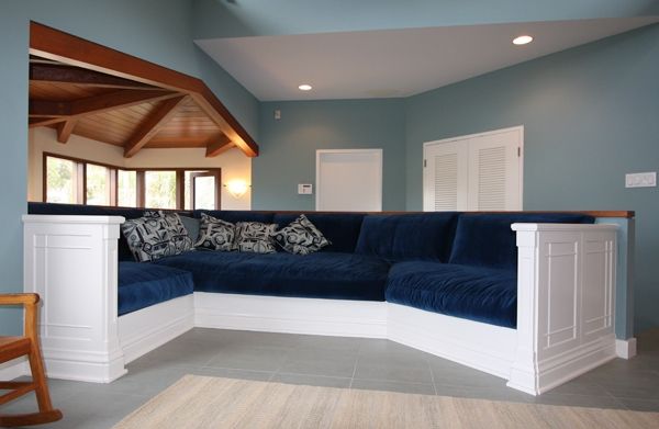 A living room with a blue sectional couch and a rocking chair