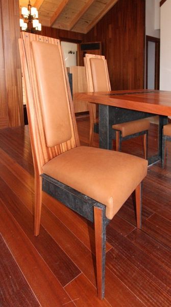 A chair with a brown leather seat sits in front of a wooden table