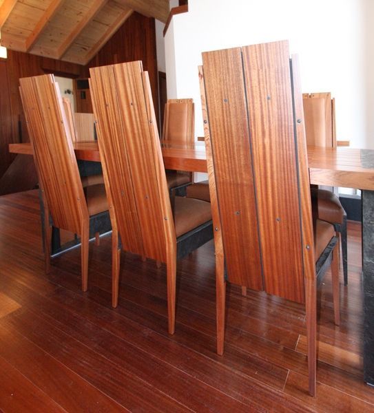 A dining room with a table and chairs made of wood