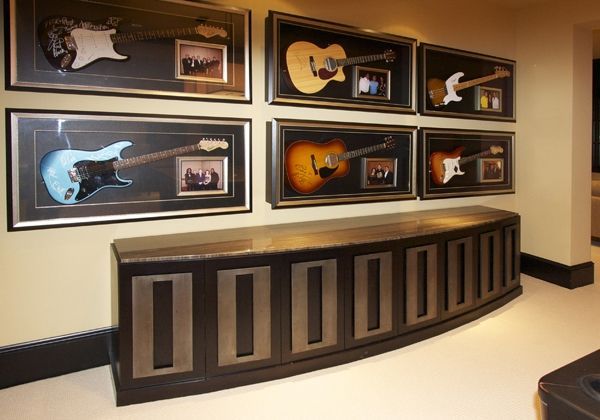 A bunch of guitars are hanging on a wall