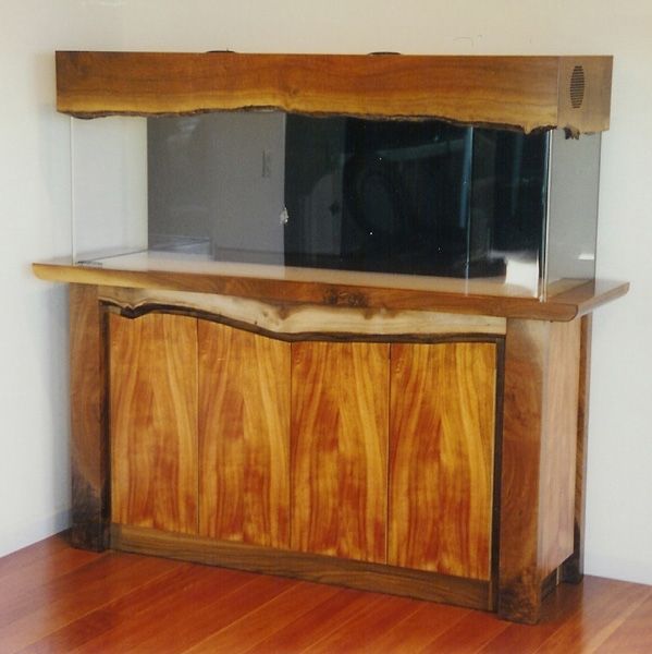 A wooden cabinet with a large aquarium on top of it