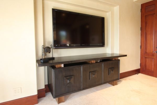 A large flat screen tv is mounted on the wall above a wooden entertainment center