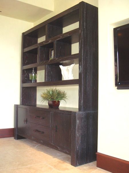 A shelf with a plant on top of it in a living room
