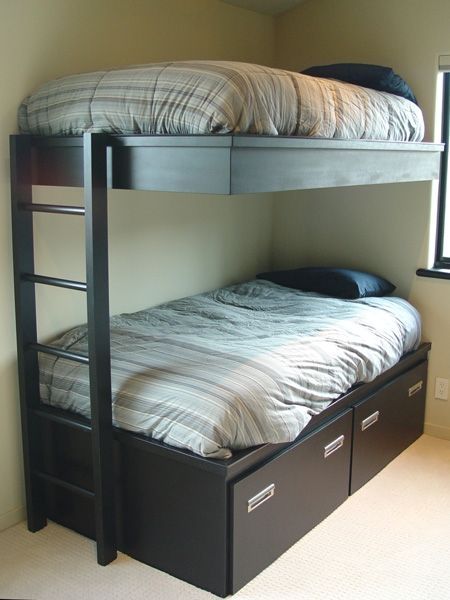A bunk bed with a ladder and drawers underneath it