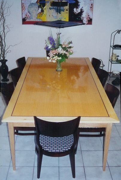 A dining room table with a vase of flowers on it