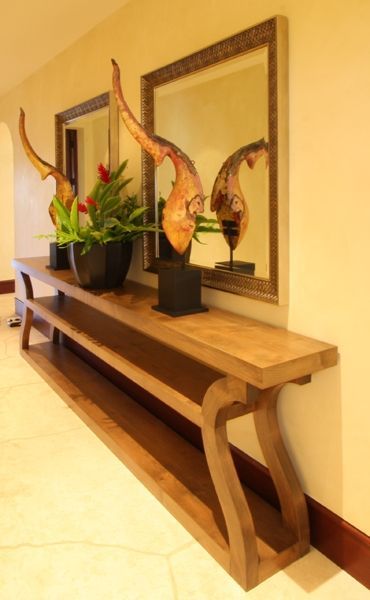 A hallway with a long wooden table and two mirrors