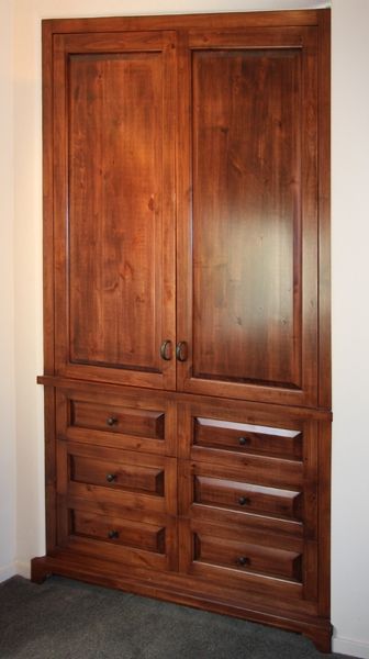 A wooden cabinet with drawers and doors in a room